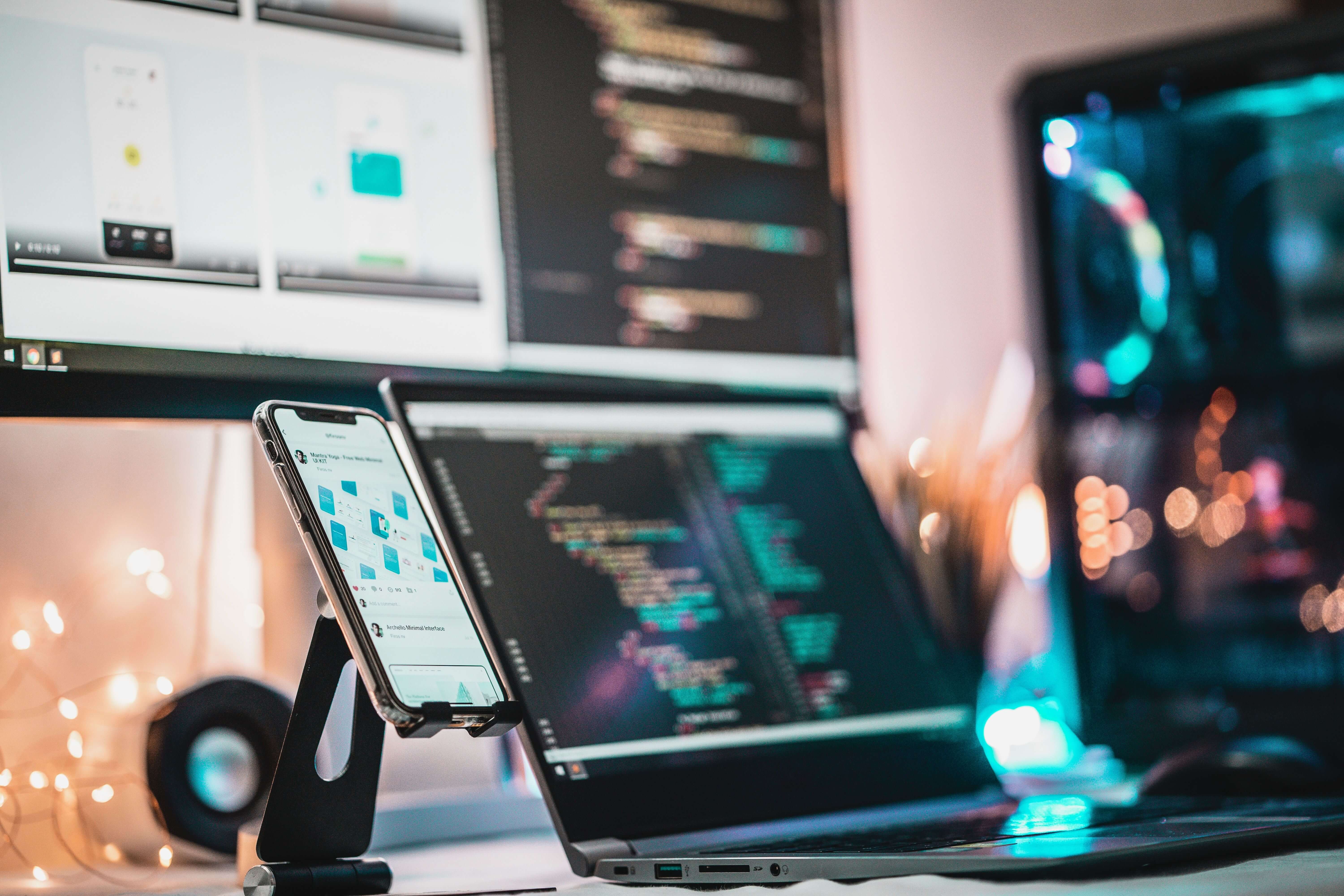 Developer test een app op een smartphone naast een laptop